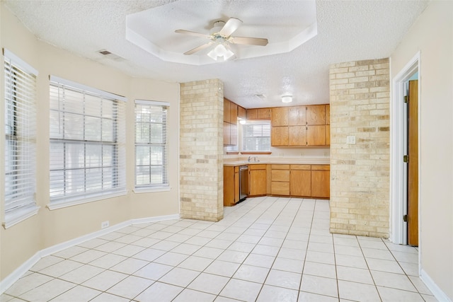 kitchen featuring a textured ceiling, ceiling fan, a raised ceiling, and light tile patterned floors