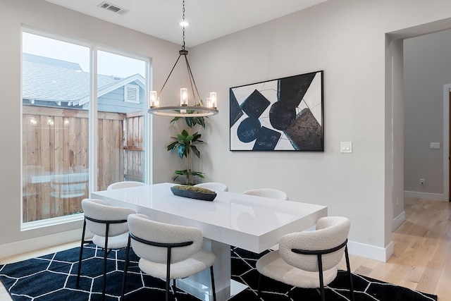 dining area featuring wood-type flooring and a chandelier