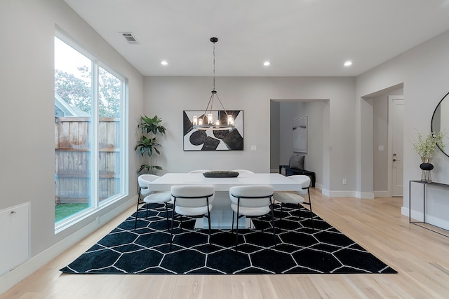 dining area featuring an inviting chandelier, plenty of natural light, and light wood-type flooring