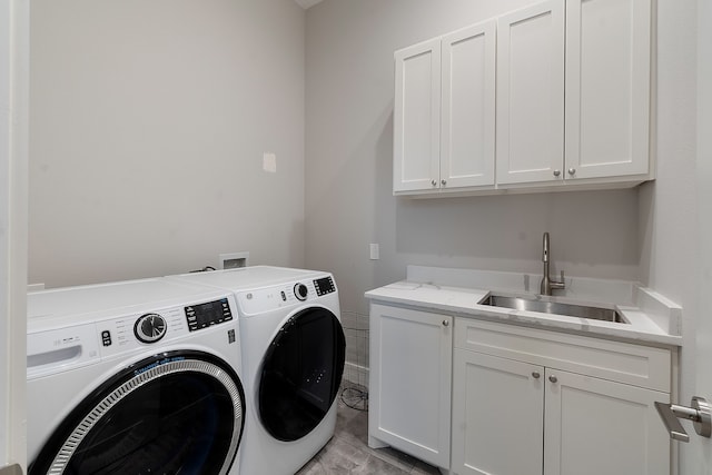 clothes washing area featuring sink, independent washer and dryer, and cabinets