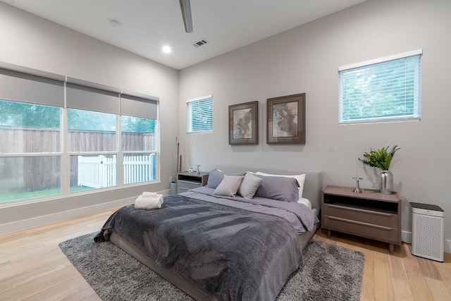 bedroom with light hardwood / wood-style flooring, multiple windows, and ceiling fan