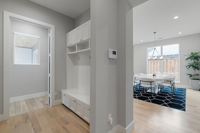 mudroom featuring a chandelier and light hardwood / wood-style floors