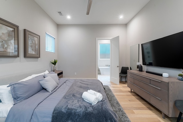 bedroom with light hardwood / wood-style floors and ensuite bath