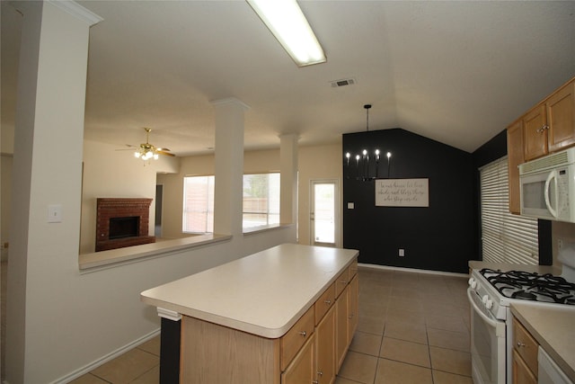 kitchen with pendant lighting, a center island, light tile patterned floors, and white appliances