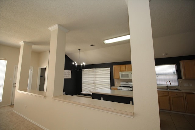 kitchen with sink, white appliances, an inviting chandelier, decorative light fixtures, and vaulted ceiling