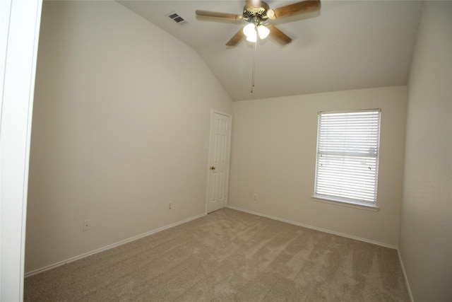 empty room with ceiling fan, vaulted ceiling, and light carpet