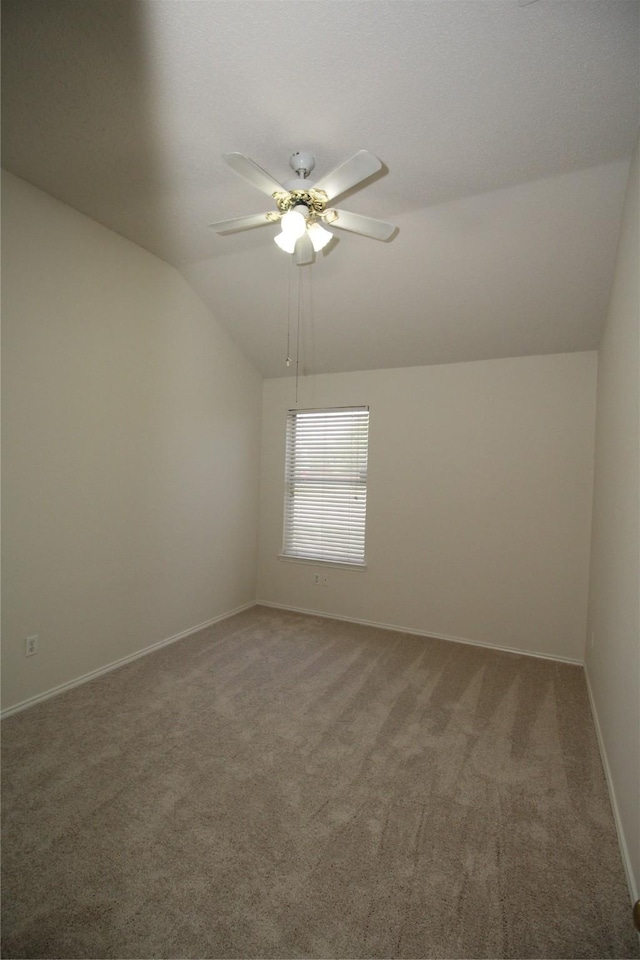 unfurnished room with lofted ceiling, ceiling fan, and carpet flooring