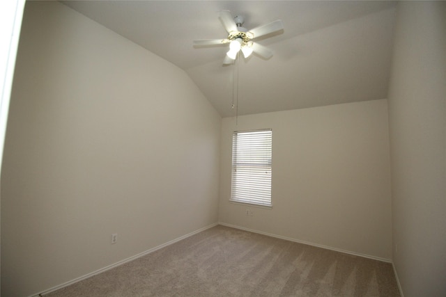 carpeted spare room with vaulted ceiling and ceiling fan