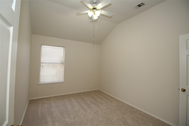 carpeted spare room featuring ceiling fan and vaulted ceiling