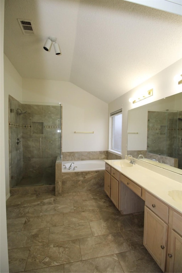 bathroom with vaulted ceiling, separate shower and tub, and vanity