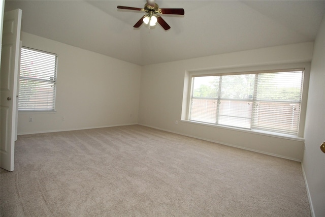 carpeted spare room featuring vaulted ceiling, a wealth of natural light, and ceiling fan