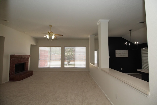 unfurnished living room with a fireplace, decorative columns, ceiling fan, and carpet