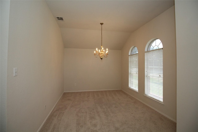 carpeted spare room with an inviting chandelier and lofted ceiling