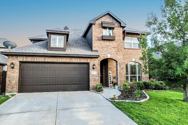 view of front of house with a garage and a yard