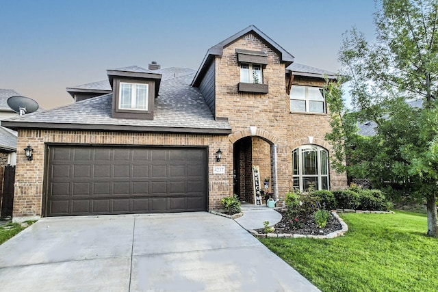 view of front of home featuring a garage and a yard