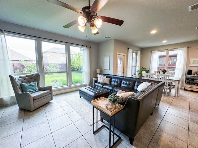 tiled living room with a textured ceiling and ceiling fan