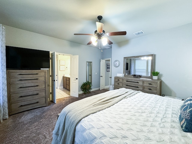 carpeted bedroom with ensuite bath and ceiling fan