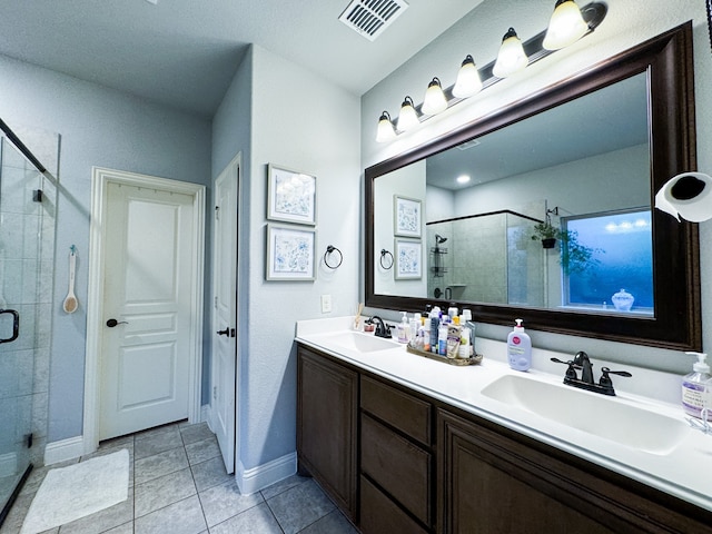 bathroom featuring dual vanity, an enclosed shower, and tile patterned flooring