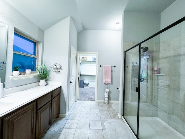 bathroom with a shower with shower door, vanity, and tile patterned floors