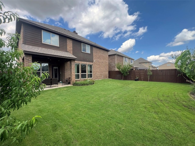 back of property with a patio area and a lawn