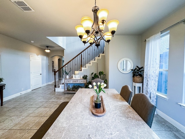 tiled dining room with a chandelier