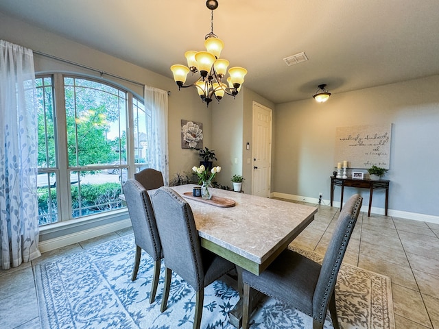 tiled dining area featuring a chandelier