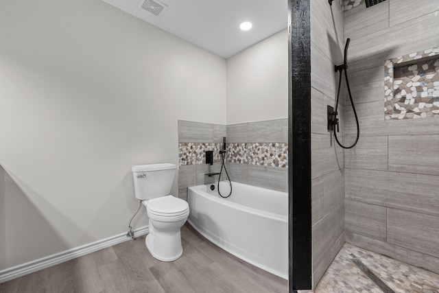 bathroom with toilet, wood finished floors, visible vents, baseboards, and a bath