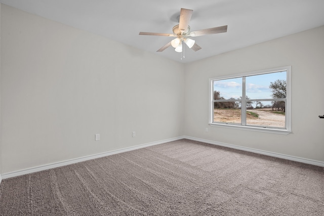 carpeted empty room featuring ceiling fan and baseboards