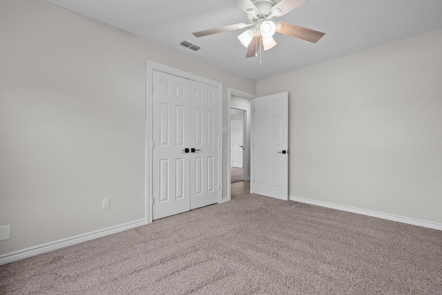 unfurnished bedroom with a closet, carpet flooring, visible vents, and baseboards