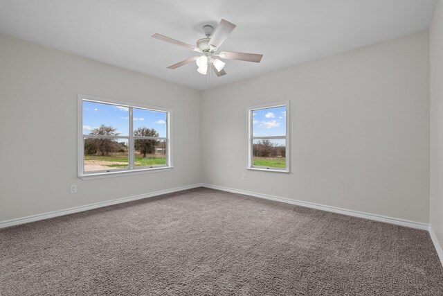 carpeted empty room featuring plenty of natural light and ceiling fan