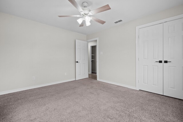 unfurnished bedroom featuring a closet, carpet floors, and ceiling fan