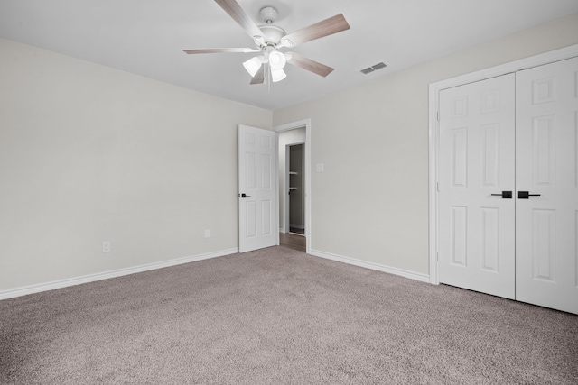 unfurnished bedroom with a closet, carpet, visible vents, and baseboards