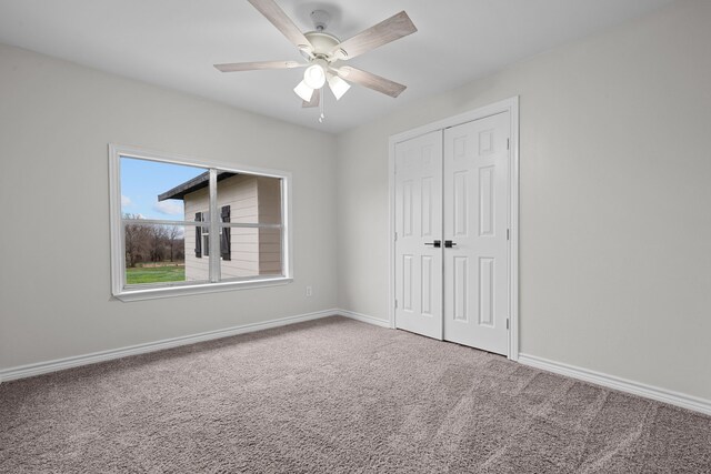 unfurnished bedroom with a closet, carpet flooring, and ceiling fan