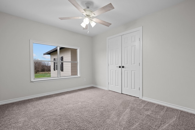 unfurnished bedroom with a ceiling fan, a closet, carpet flooring, and baseboards