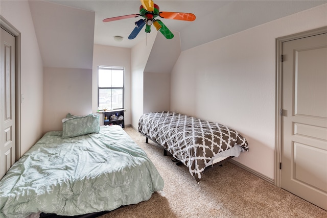 carpeted bedroom featuring ceiling fan and vaulted ceiling