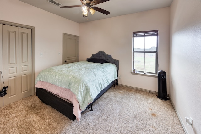 bedroom featuring light colored carpet, a closet, and ceiling fan