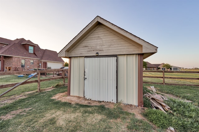 outdoor structure at dusk featuring a lawn