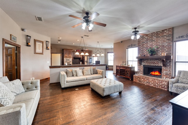 living room with plenty of natural light, ceiling fan, and dark hardwood / wood-style floors