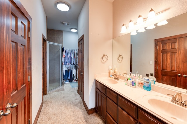 bathroom with an enclosed shower and dual bowl vanity