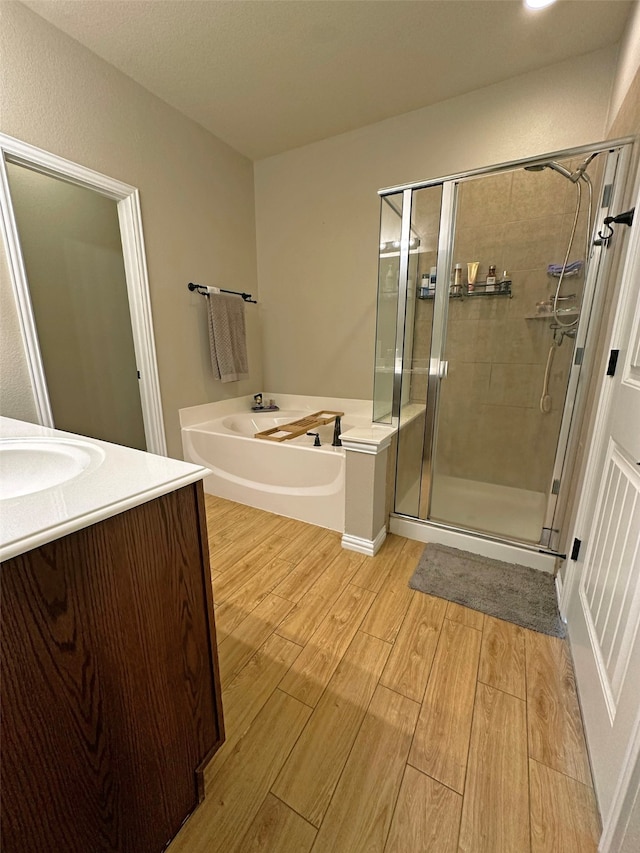 bathroom with vanity, shower with separate bathtub, and hardwood / wood-style floors