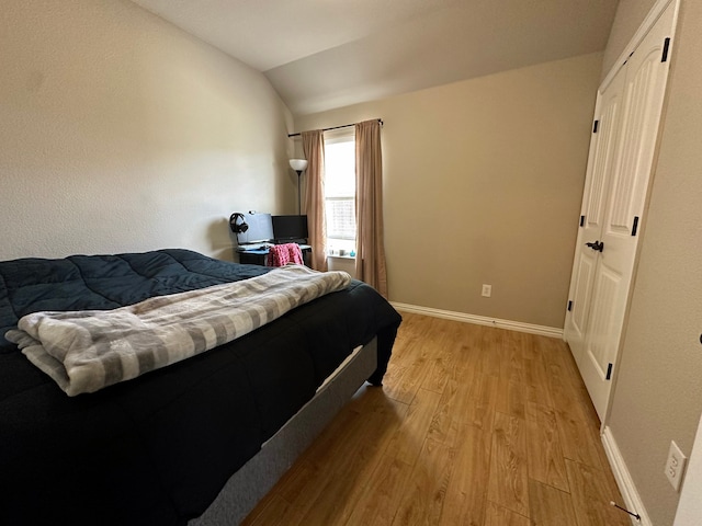 bedroom with light hardwood / wood-style flooring and lofted ceiling