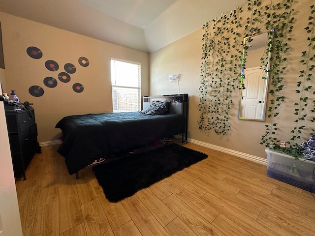 bedroom with hardwood / wood-style flooring and lofted ceiling