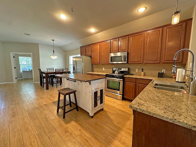 2205 Willow Creek Dr, Little Elm, TX 75068 - kitchen featuring sink, a center island, hanging light fixtures, stainless steel appliances, and light hardwood / wood-style floors