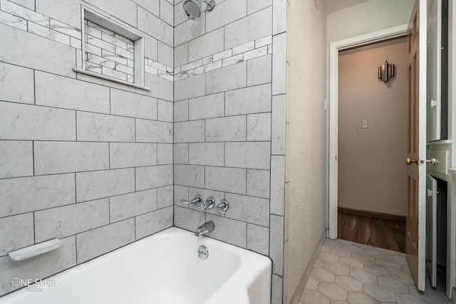 bathroom featuring tile patterned flooring and tiled shower / bath