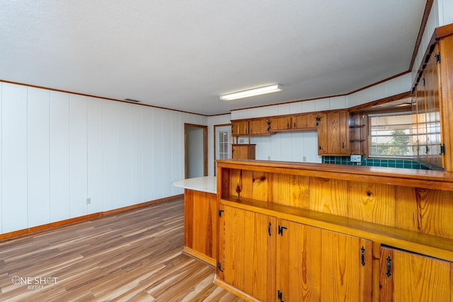 kitchen featuring crown molding and light hardwood / wood-style flooring