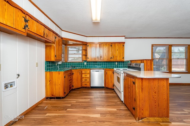 kitchen with white range with electric cooktop, stainless steel dishwasher, light hardwood / wood-style floors, and kitchen peninsula