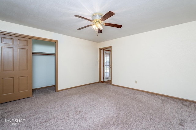 unfurnished bedroom with ceiling fan, carpet floors, a closet, and a textured ceiling