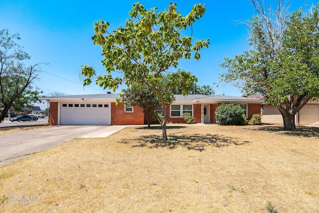 ranch-style house with a garage and a front lawn