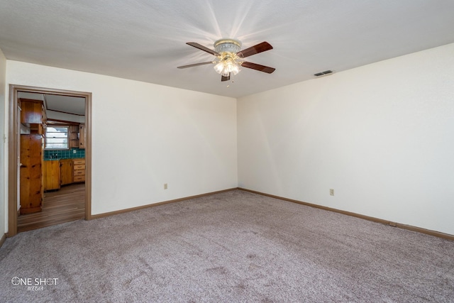 empty room with ceiling fan and carpet floors