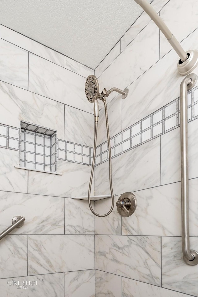 interior details featuring a tile shower